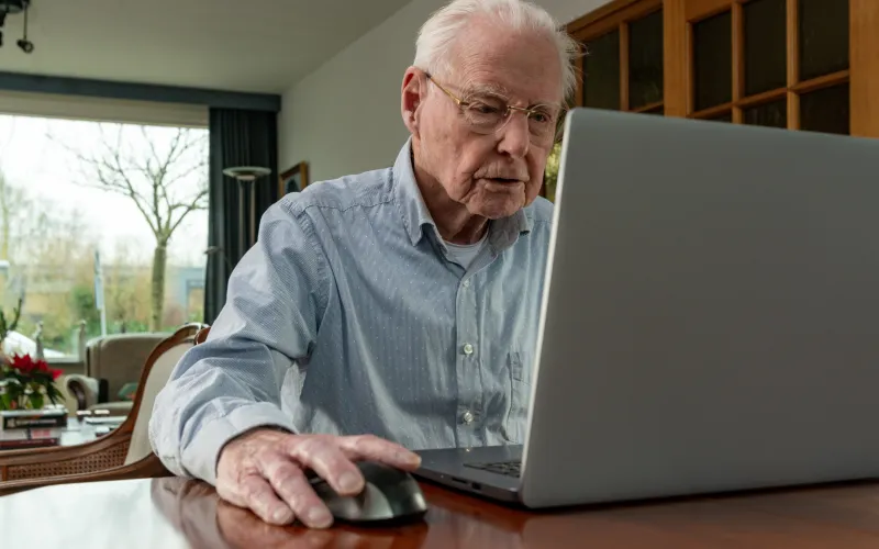 man zit achter een laptop
