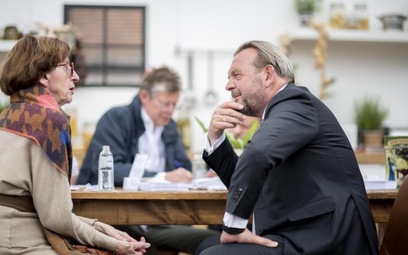 Reinier van Zutphen in gesprek met een oudere vrouw tijdens de provincietour in Friesland