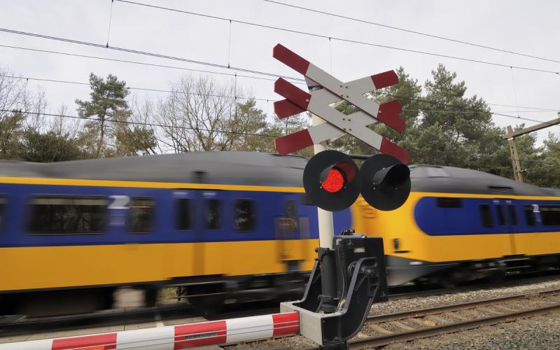 Foto van een spoorwegovergang waar een trein langs komt Foto van een spoorwegovergang waar een trein langs komt
