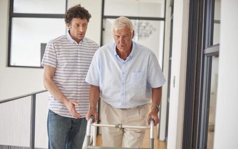 man met rollator en begeleider man met rollator en begeleider