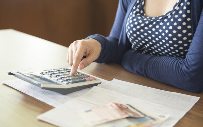 Vrouw met rekenmachine en geld