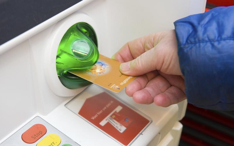 Man pint geld bij pinautomaat