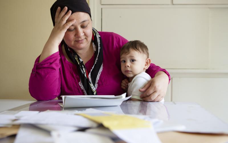 Vrouw met hoofddoek heeft haar kind op schoot