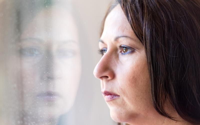 Foto van een vrouw die uit het raam kijkt Foto van een vrouw die uit het raam kijkt
