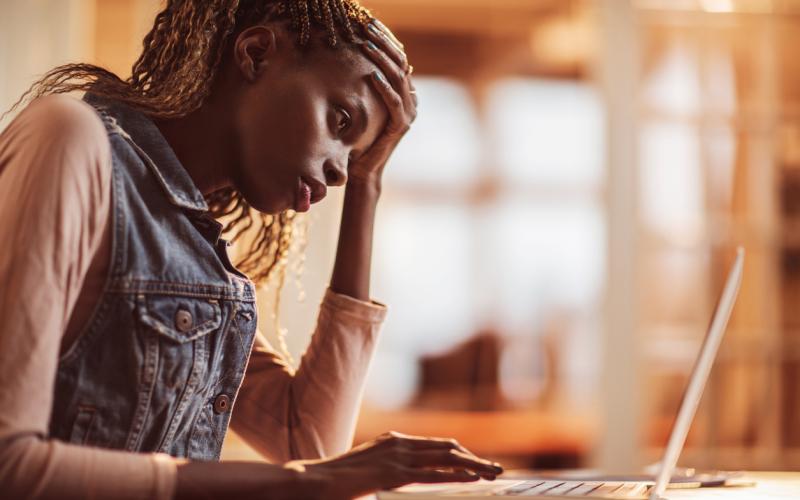 Getinte vrouw kijkt naar laptop Getinte vrouw kijkt naar laptop
