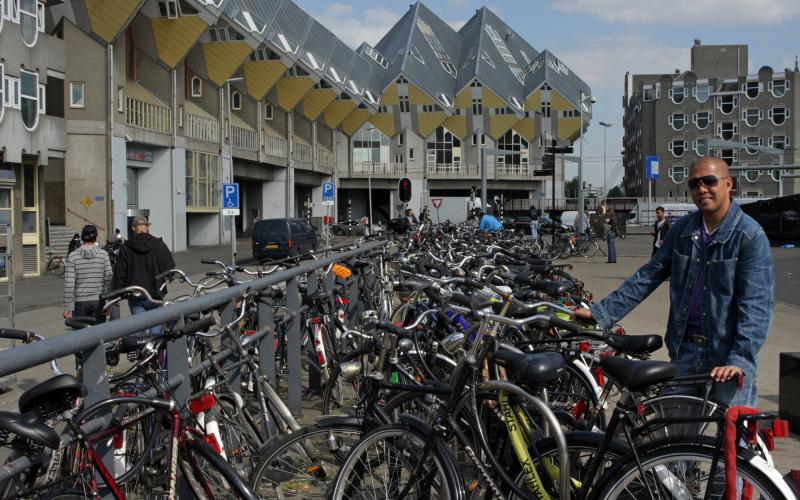 man met fiets bij kubuswoningen in Rotterdam