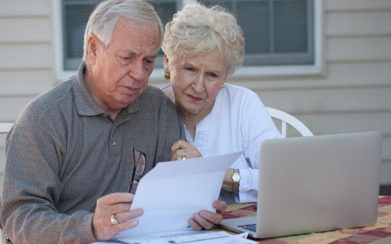 Ouder echtpaar kijkt post in en kijkt bezorgd