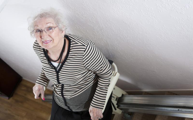 Foto van een vrouw en traplift