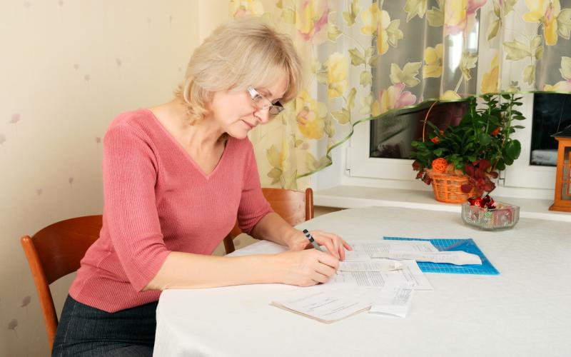 Vrouw met documenten aan tafel Vrouw met documenten aan tafel