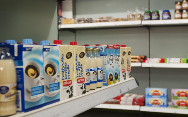 Een winkelschap met pakken houdbare melk Een winkelschap met pakken houdbare melk