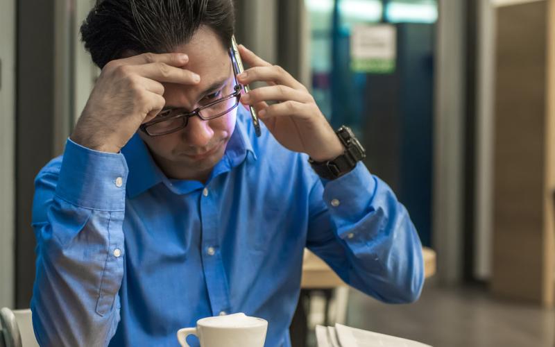 man aan de telefoon kijkt machteloos man aan de telefoon kijkt machteloos