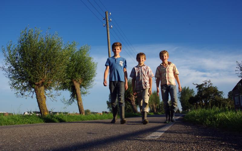 Drie jonge jongens wandelen over straat Drie jonge jongens wandelen over straat