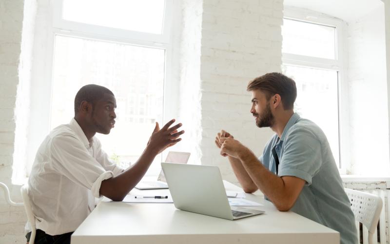 Man spreekt met andere man aan een tafel op Bonaire Man spreekt met andere man aan een tafel op Bonaire