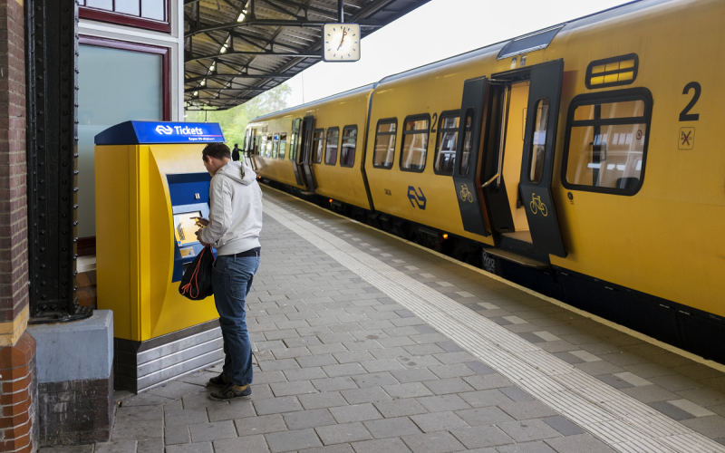 Man koopt treinkaartje op het station Man koopt treinkaartje op het station