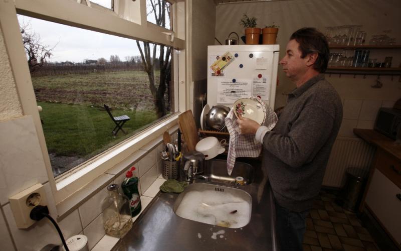 Man in de keuken met afwas