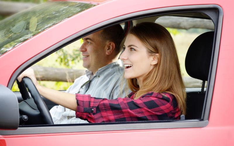 Meisje rijdt in auto met examinator Meisje rijdt in auto met examinator