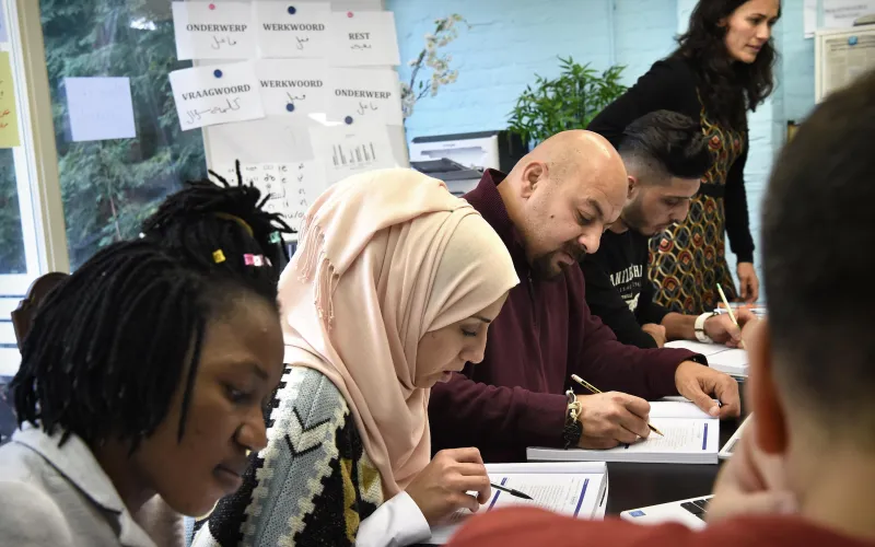 Mensen nemen deel aan een taalles bij inburgering