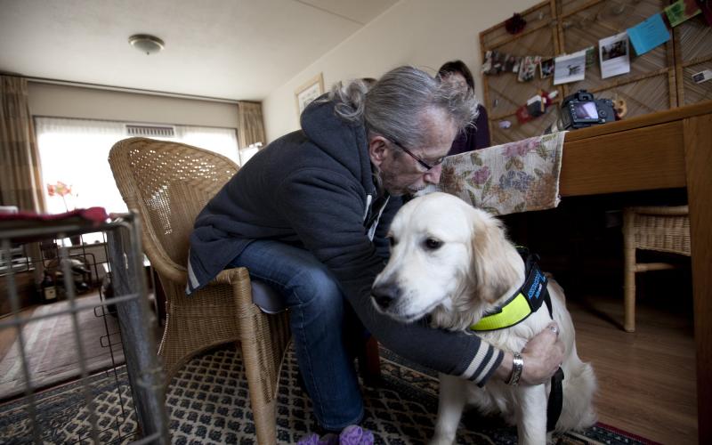 Foto van een man met een hulphond Foto van een man met een hulphond