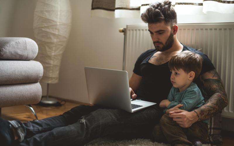 Man met laptop en kind