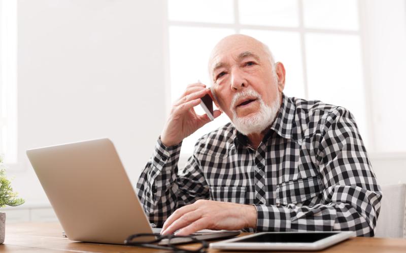 Man met laptop en mobiele telefoon