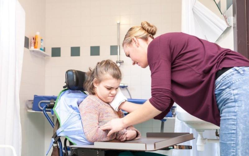 Gehandicapt meisje met verzorger Gehandicapt meisje met verzorger