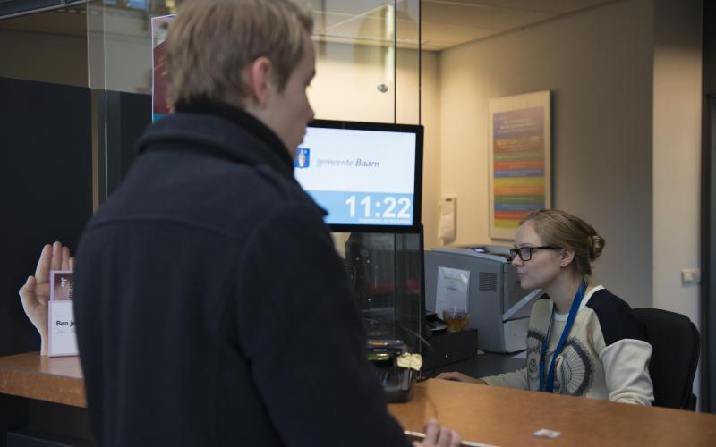 Jongen aan het loket bij de gemeente