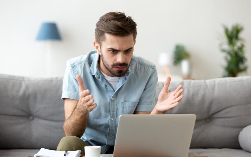 Man kjikt verbaasd naar zijn laptop Man kjikt verbaasd naar zijn laptop