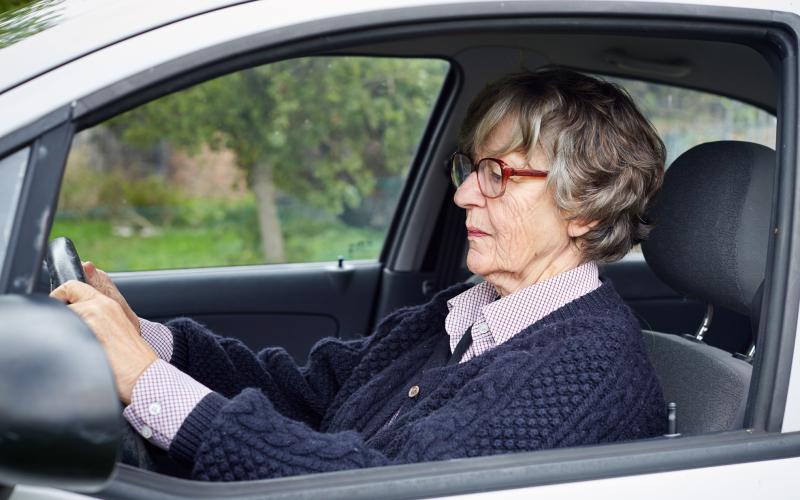 Foto van een oudere dame in de auto