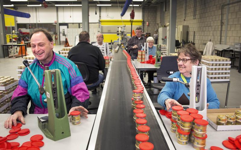 Een sociale werkplaats, twee mensen lachen tijdens het werk Een sociale werkplaats, twee mensen lachen tijdens het werk