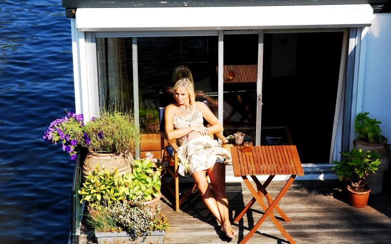 vrouw zit in de zon op woonboot vrouw zit in de zon op woonboot