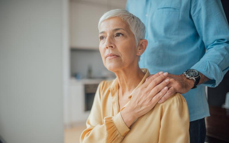 Man legt hand op schouder van zijn vrouw