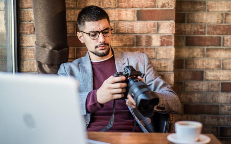 Man met digitale camera in zijn handen