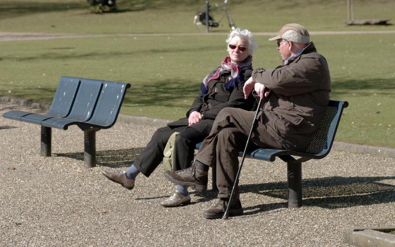 Senioren koppel op bank in park