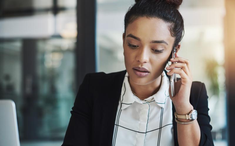 Jonge vrouw in nette kleding in een telefoongesprek