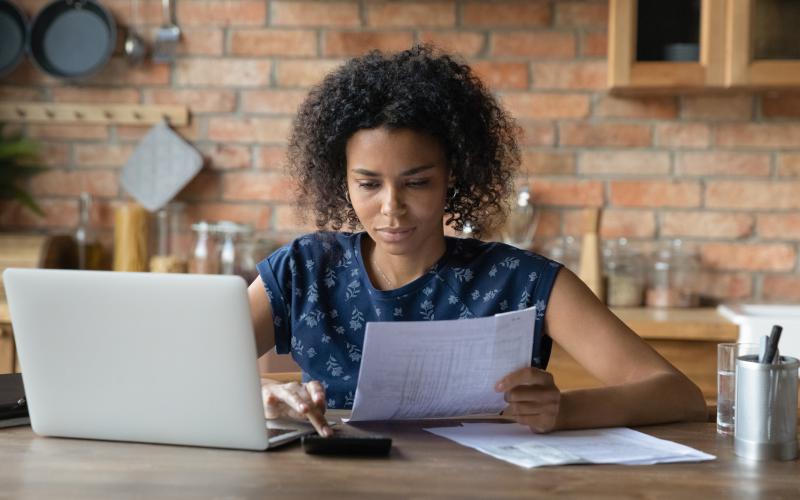 Vrouw werkt met laptop en documenten Vrouw werkt met laptop en documenten