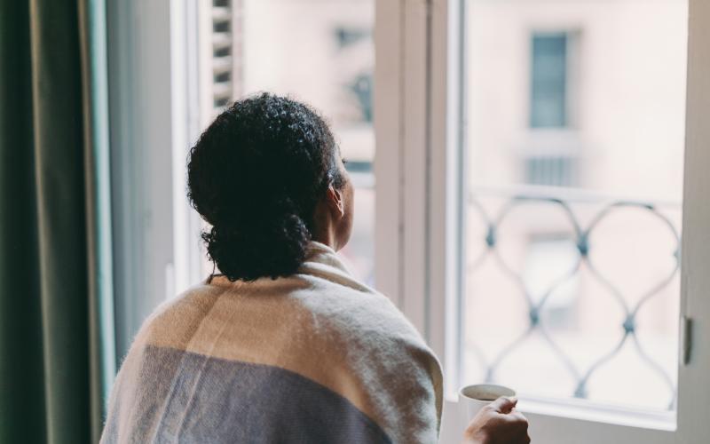 Vrouw kijkt uit raam Vrouw kijkt uit raam