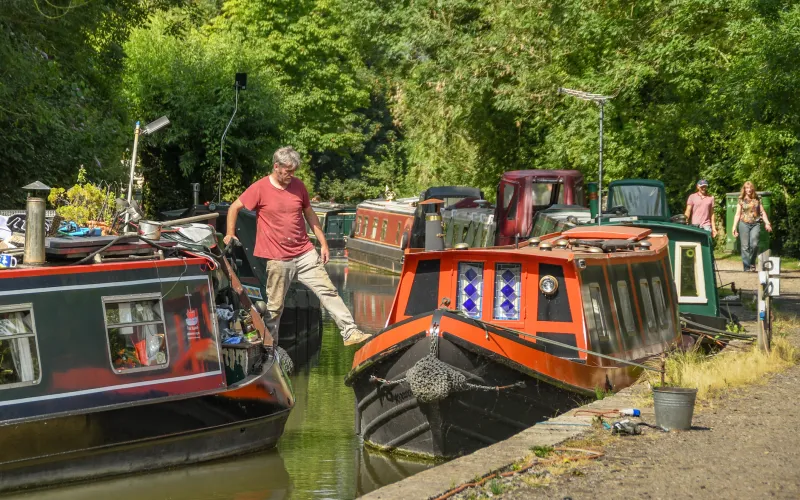 Man stapt van ene woonboot op andere woonboot