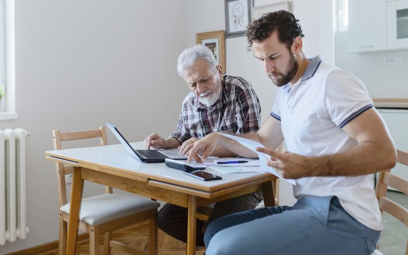 Twee mannen aan tafel bezig met de financiën