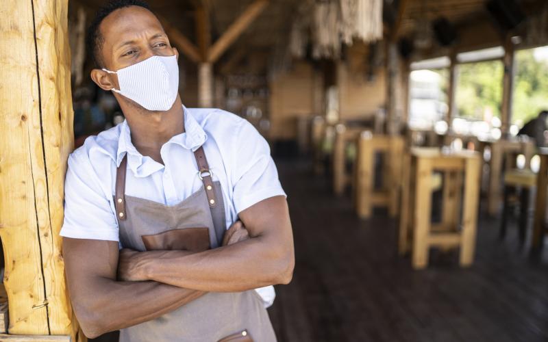 Man met mondkapje in strandtent (bij column over Tegemoetkoming Vaste Lasten