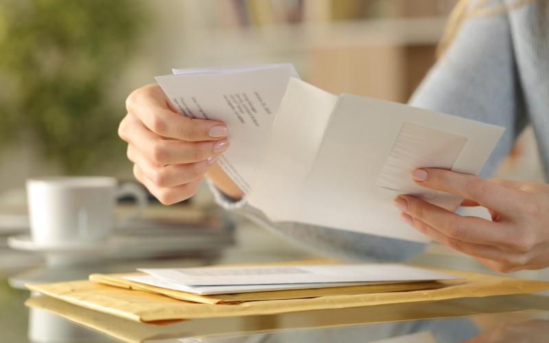 Handen van een vrouw die brieven vasthoudt