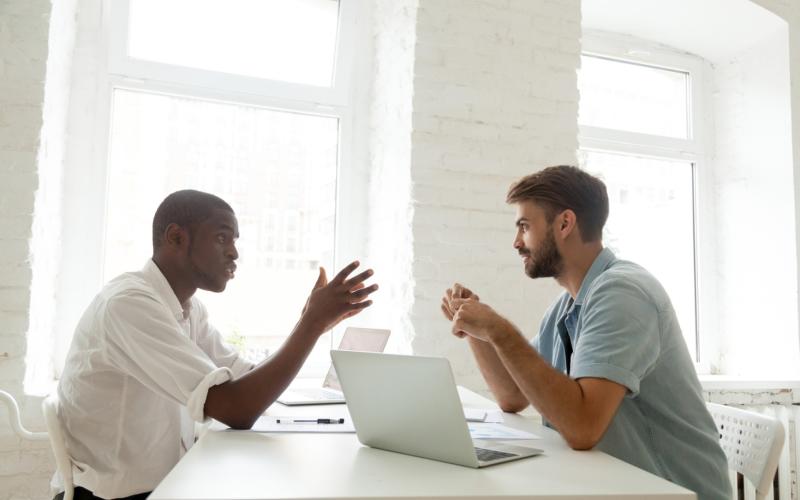 Twee mannen in gesprek aan tafel