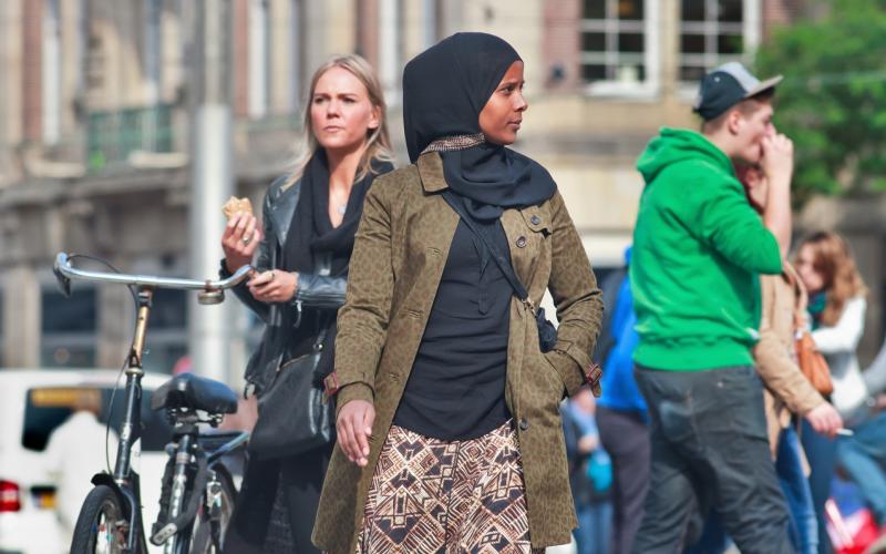 Zwarte vrouw met hoofddoek in een drukke straat