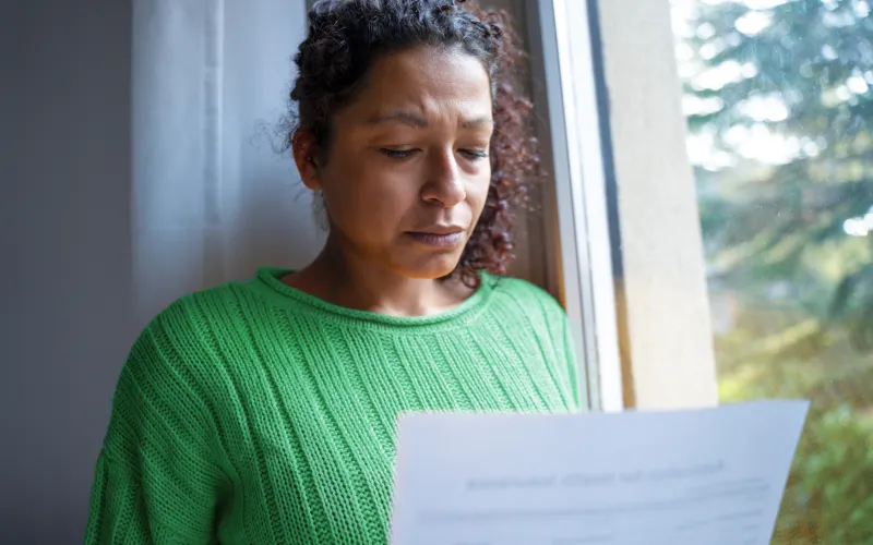 Vrouw kijkt bezorgd naar rekeningen