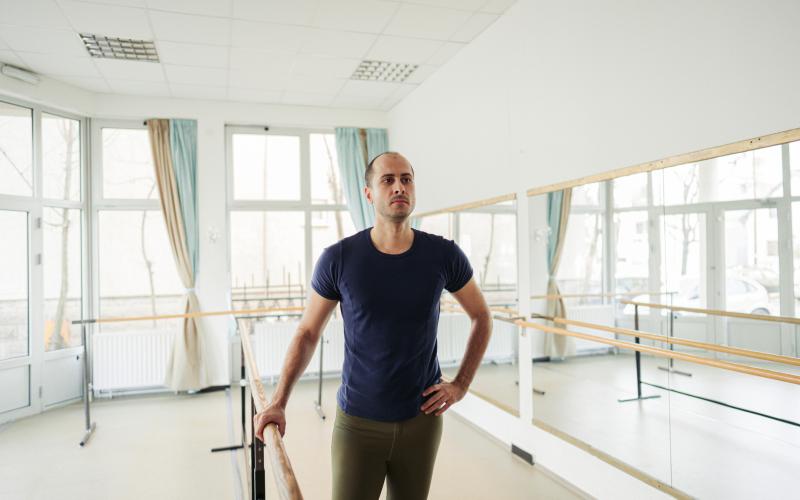 Een man van middelbare leeftijd met donker haar staat in een dansschool.