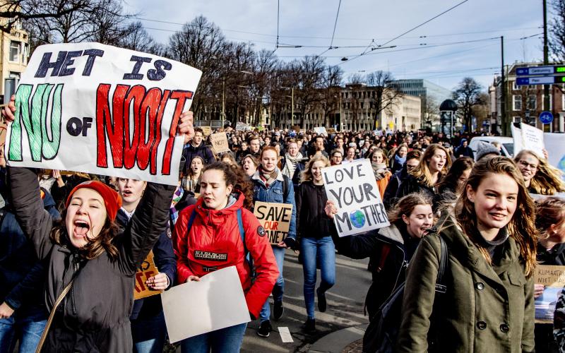 een grote groep mensen demonstreert in Amsterdam