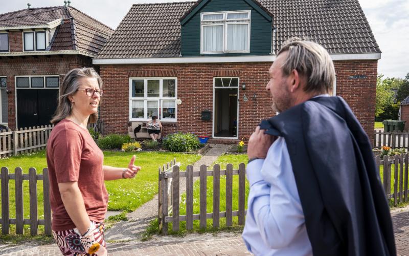 Nationale ombudsman Reinier van Zutphen spreekt met vrouw in Groningen voor haar huis over schade gaswinning
