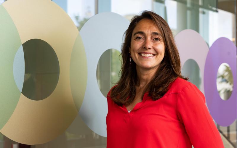 Vrouw met halflang donker haar (Gaby von Maltzahn, Nationale ombudsman). Ze lacht en draagt een rood shirt