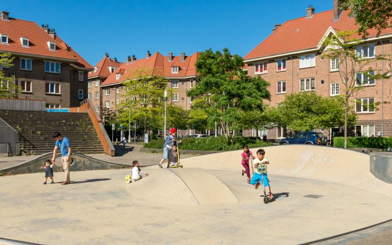 Spelende kinderen op een speelplein in de bebouwde kom