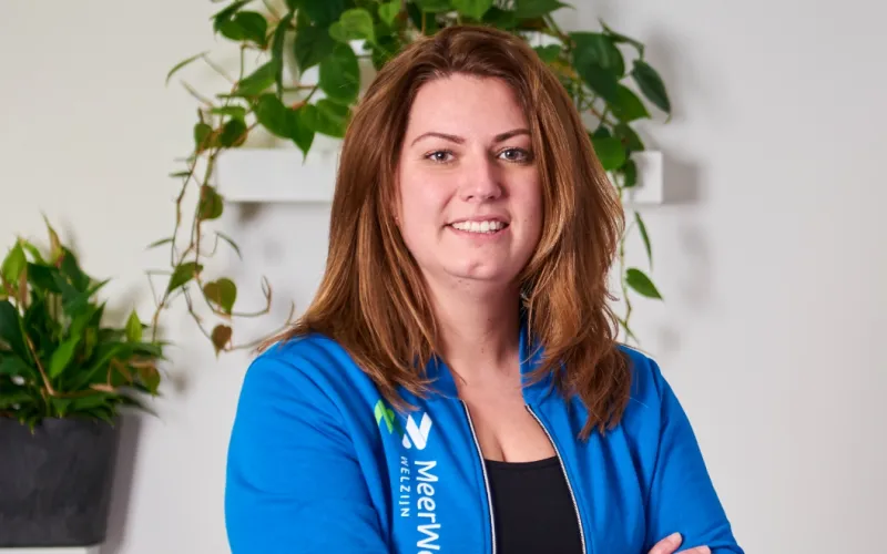 Vrouw (Simone Duin) met lang roodgekleurd haar. Ze draagt een blauwe blouse