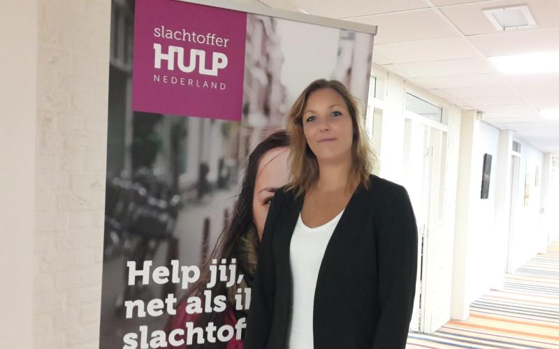 Vrouw (Simone Schuitema) met lang donkerblond haar, draagt wit shirt en zwart jasje. Ze staat in een gang met een gestreepte vloer Vrouw (Simone Schuitema) met lang donkerblond haar, draagt wit shirt en zwart jasje. Ze staat in een gang met een gestreepte vloer